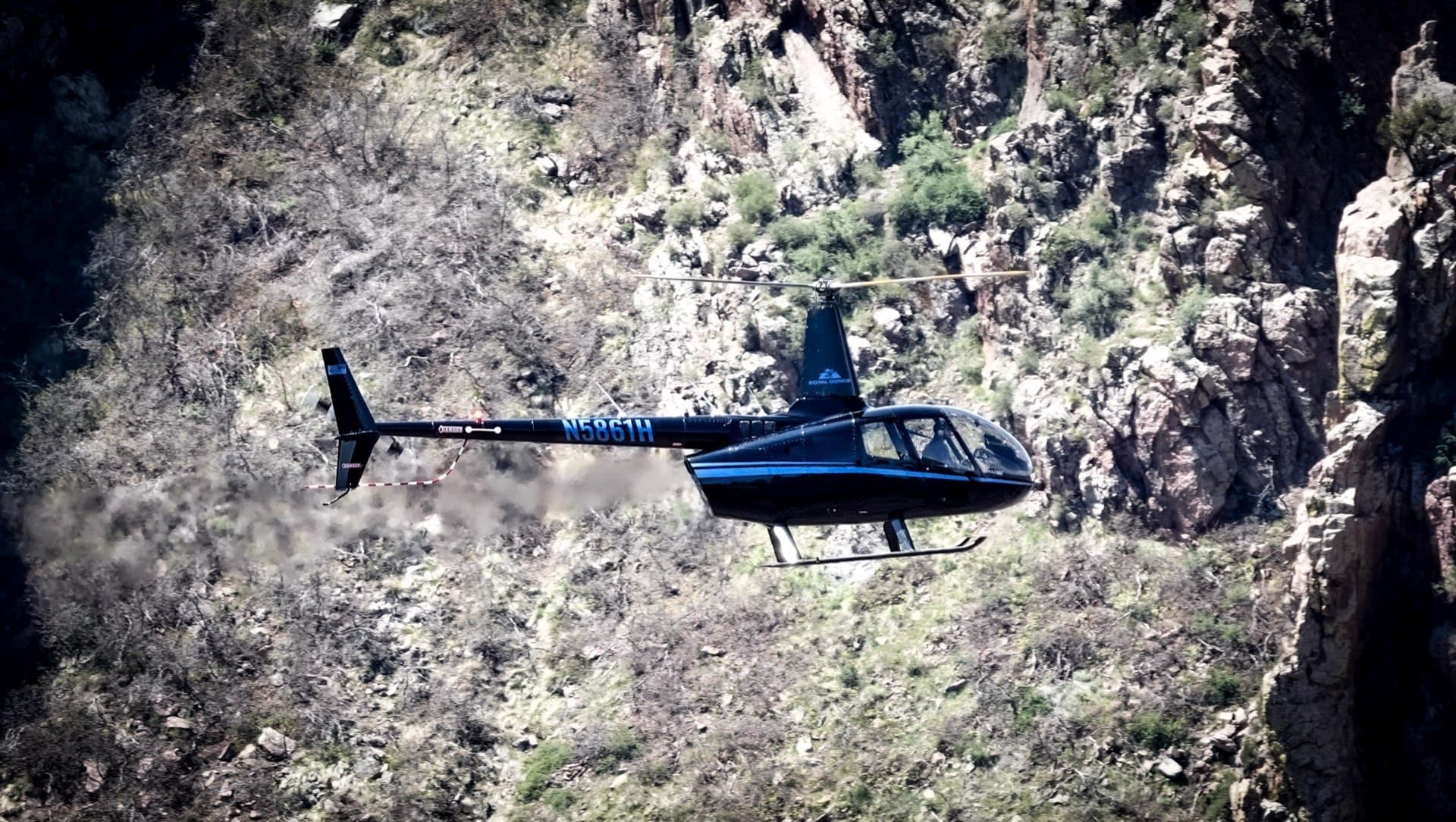 Robinson R44 banking through the Royal Gorge in warm afternoon light